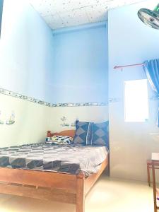 a bedroom with a bed with blue walls at NHÀ NGHỈ TÂM AN in Châu Thành