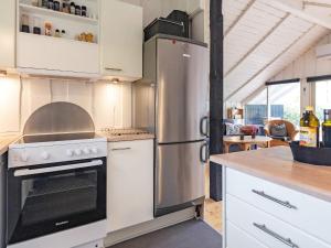 a kitchen with a stove and a refrigerator at Holiday home Tranekær XVIII in Tranekær