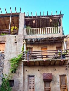ein altes Gebäude mit Balkon darüber in der Unterkunft نزل حارة المسفاة Harit AL Misfah Inn in Misfāh
