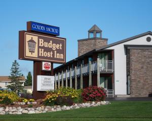 a building with a sign for a budget host inn at Budget Host Inn & Suites in Saint Ignace