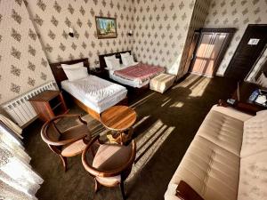 a room with two beds and a table and chairs at Boulevard Palace Hotel in Samarkand