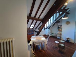 a room with a table and chairs in a attic at Magnifique Appartement Beaux arts in Tours