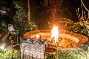 a table and chairs with a fire pit at Galalima Glamping in Tabanan