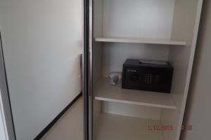 a small refrigerator with a microwave in a cabinet at Mai Khao Beach Apartments -MBC- in Ban Bo Sai Klang