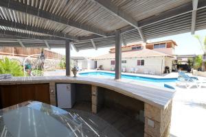 un patio al aire libre con piscina y pérgola en viktoryadream, en Eilat