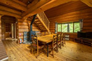 une salle à manger avec une table en bois et une cheminée dans l'établissement Reposer Hakuba, à Hakuba