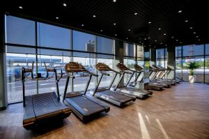 una fila de cintas de correr en un gimnasio con ventanas en Wyndham Garden Baku, en Baku