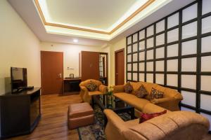 uma sala de estar com sofás e uma televisão de ecrã plano em HOTEL SHINKHAM GRAND em Gangtok