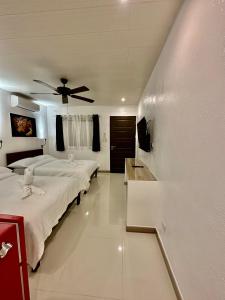 a bedroom with two beds and a ceiling fan at Calypso Beach and Dive Resort in Boracay