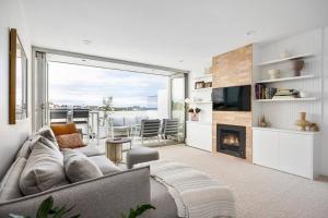 a living room with a couch and a fireplace at Sandy@Village - newly renovated + bay views in Sandringham