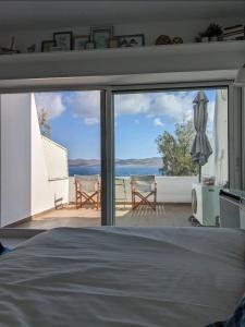 a bedroom with a bed and a view of the ocean at Sea Satin Sounio in Sounio