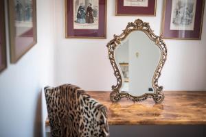 ein Spiegel auf einem Tisch mit einem Stuhl in der Unterkunft Werners Boutique Hotel in Fürth