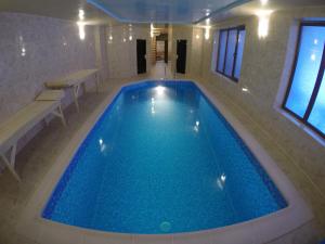 a large swimming pool with blue water in a building at Lavina Hotel in Bukovel