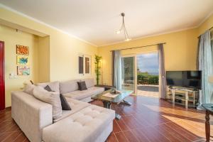 a living room with a couch and a tv at Villa Socrates in Skala Kefalonias