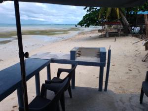 Daanbantayan的住宿－Little Sanity Beach house，海滩上的蓝色桌椅