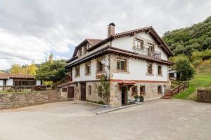 a large stone house with a large driveway at Apartamento Valverde II in Potes