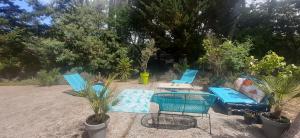 a patio with two blue chairs and a table at Mon petit coin sous les pins in La Teste-de-Buch