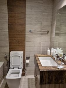 a bathroom with a toilet and a sink and a tub at Grand Stay Holiday Homes Al Jaddaf in Dubai