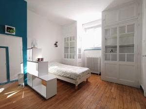 um quarto com uma cama e uma porta branca em Chambres d'hôtes La Maison Blanche em Saint-Junien