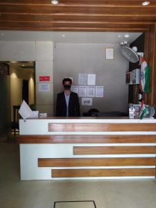 a man is standing behind the counter of a practition at Hotel MEGHA INN in Lucknow