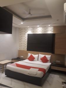 a bedroom with a large bed with red pillows at Hotel MEGHA INN in Lucknow