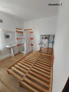 Schlafzimmer mit Bettrahmen und Waschbecken in der Unterkunft Chambres privatives avec espaces partagés dans maison Roubaix centre in Roubaix