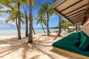 a beach house with a green couch on the beach at Outrigger Koh Samui Beach Resort - SHA Extra Plus in Lamai