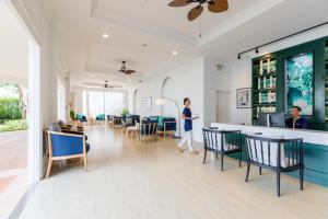 a man standing in a room with a bar at Outrigger Koh Samui Beach Resort - SHA Extra Plus in Lamai