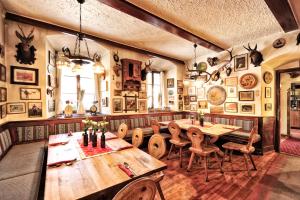 a restaurant with wooden tables and chairs in a room at Fischerwirt am See in Achenkirch