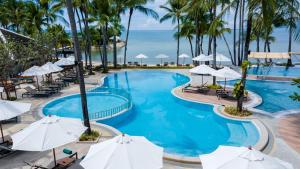 an image of a pool at a resort with palm trees and the ocean at Outrigger Koh Samui Beach Resort - SHA Extra Plus in Lamai
