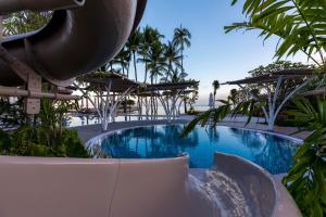 a pool at a resort with a water slide at Outrigger Koh Samui Beach Resort - SHA Extra Plus in Lamai