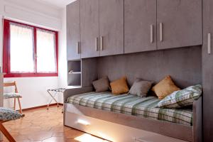 a bed in a room with cabinets and a couch at Casina di Liliana in Livorno