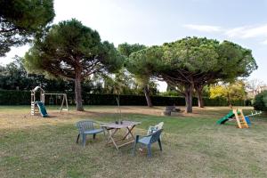 a park with a table and chairs and a playground at Casina di Liliana in Livorno