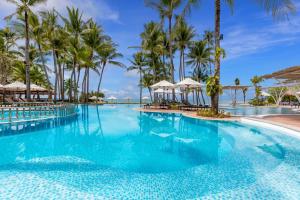 a swimming pool at the resort at Outrigger Koh Samui Beach Resort - SHA Extra Plus in Lamai