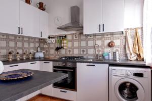 a kitchen with white cabinets and a washing machine at Casina di Liliana in Livorno