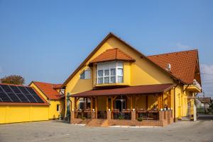 una casa gialla con pannelli solari di Betli Panzió a Zalaegerszeg