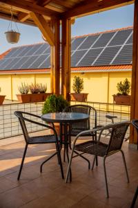 un tavolo e sedie su un patio con pannelli solari di Betli Panzió a Zalaegerszeg