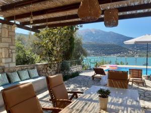 a patio with a table and chairs and a pool at Villa Panorea in Yénion