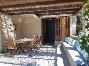 a patio with a wooden table and chairs at Villa Panorea in Yénion