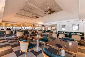 a restaurant with tables and chairs and a bar at Outrigger Koh Samui Beach Resort - SHA Extra Plus in Lamai