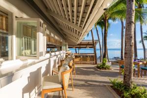 a row of chairs and tables on a building with the beach at Outrigger Koh Samui Beach Resort - SHA Extra Plus in Lamai