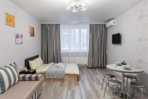 a bedroom with a bed and a table in a room at Апартаменты в новом жилом комплексе Кристалл in Tyumen