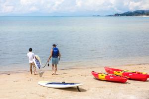 two men standing on the beach with their surfboards at Outrigger Koh Samui Beach Resort - SHA Extra Plus in Lamai