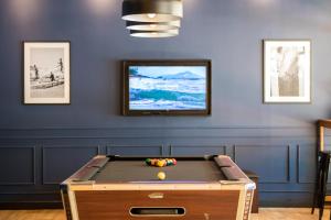 a room with a pool table in front of a wall at Outrigger Koh Samui Beach Resort - SHA Extra Plus in Lamai