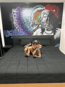 a young girl is laying on a bed in front of a mural at The Green Spot in Pattaya Central