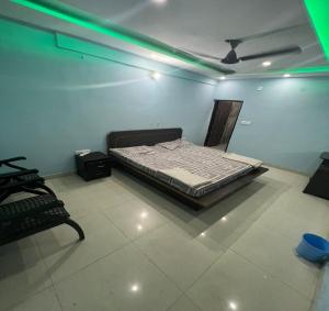 1 dormitorio con 1 cama en una habitación con luces verdes en Shanti Guest House, Sonipat en Sonipat