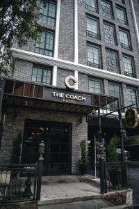 a building with a sign that reads the coach hotel at Montraj Coach Sukhumvit Bangkok in Bangkok