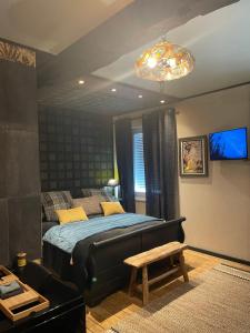 a bedroom with a bed and a chandelier at Cosy Central House with luxury jacuzzi bath in Hesdin