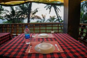 une table avec une assiette et une bouteille d'eau dessus dans l'établissement Club 7 Beach Resort, à Kannur