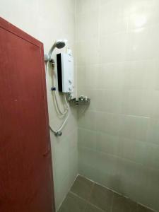 a bathroom with a shower with a soap dispenser on the wall at DAOH'S Rooms & Scooters in Tanjung Rhu +69 photos